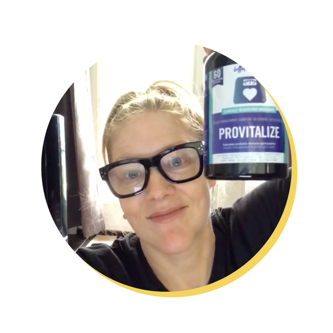 A person holding a bottle of Provitalize supplement, smiling at the camera.
