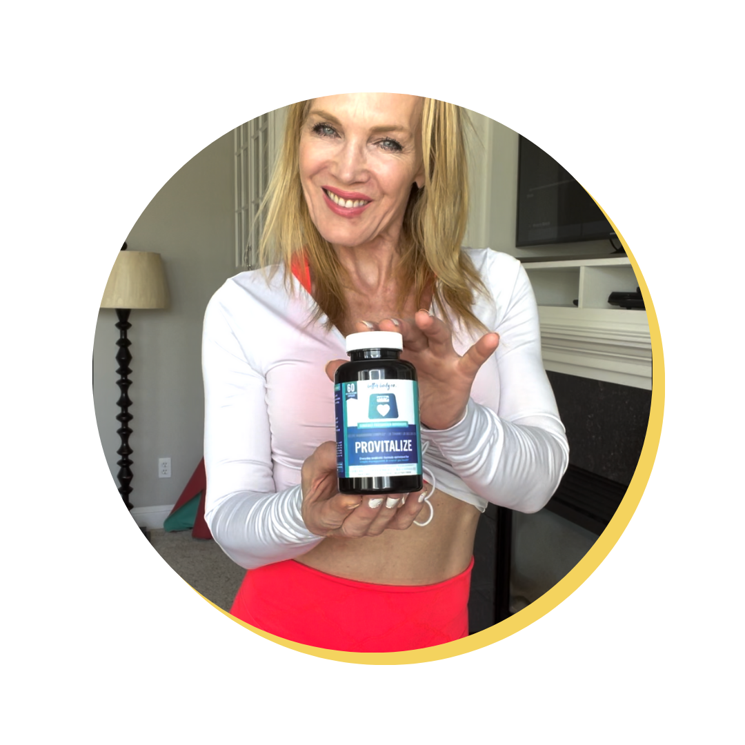 Person holding a bottle of Provitalize supplement and smiling indoors.